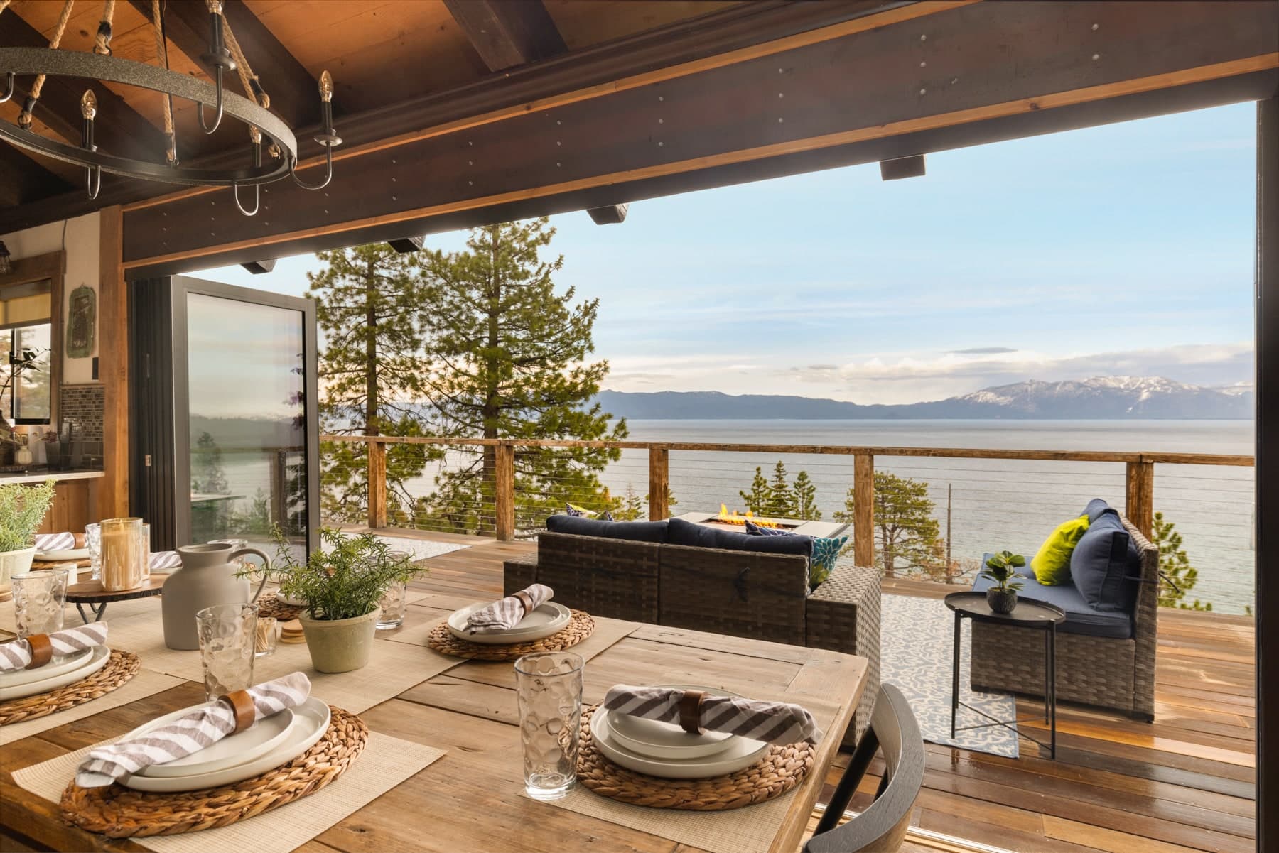 Covered dining deck overlooking Lake Tahoe through tall pine trees