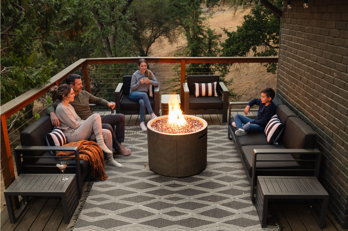 Four people around the fire pit at dusk